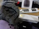 a pile of clothes and a box on a bed