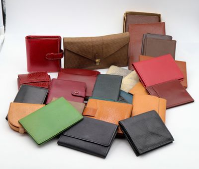 de nombreux portefeuilles en cuir de différentes couleurs posés sur une surface blanche