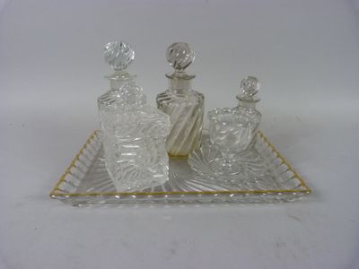 trois bouteilles en verre posées sur un plateau, sur une surface blanche