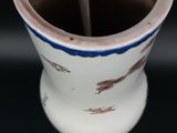 a white cup with a blue stripe on it