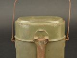 a small green container with a handle on a table