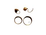 two rings and a pair of earrings on a white surface