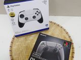 La boîte est ouverte sur la table, à côté de la manette de jeu.