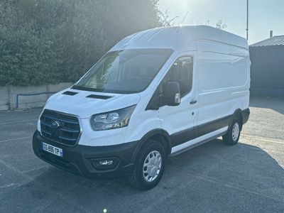 La camionnette blanche est garée sur le parking près des arbres.