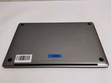 the back of a silver laptop with a blue sticker on it