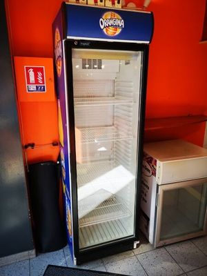 un réfrigérateur qui se trouve dans le coin d'une pièce
