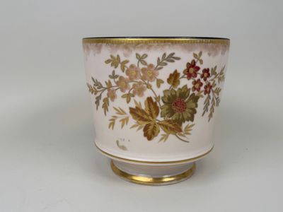 un vase blanc à bord doré avec des fleurs dessus