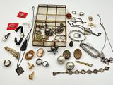 une boîte remplie de bijoux variés posée sur une surface blanche