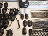 a desk with a laptop, keyboard, mouse, and other electronics on it
