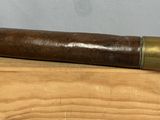 un vieux télescope posé sur un bloc de bois, sur fond blanc