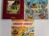 trois livres posés sur une table blanche, avec une couverture rouge