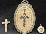 three pieces of jewelry including a cross, a locke, and a pendant
