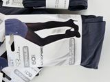 three pairs of black and white tights on display in a box