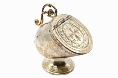 un vase en argent surmonté d'une horloge