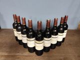 six bottles of wine are lined up on a wooden table