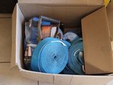 une boîte en carton posée par terre et remplie d'objets divers