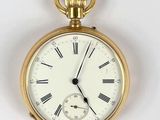 a gold pocket watch with roman numerals on the face