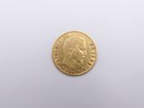 a close up of a gold coin on a white surface