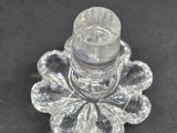 a glass candle holder with a glass candle on top of it