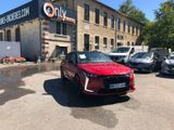 the red car is parked in front of a large building