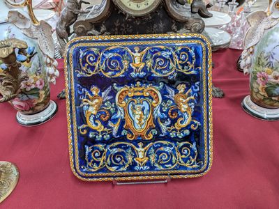 une horloge posée sur une table où se trouvent de nombreux vases