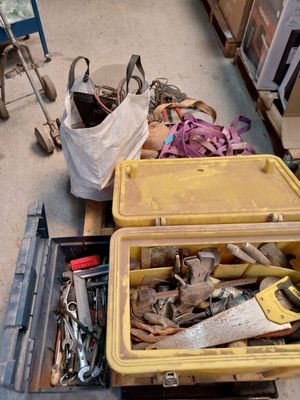 une boîte jaune posée par terre, contenant des outils