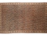 un tapis ancien avec un motif floral sur fond blanc