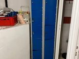 a blue locker in the corner of a room next to a white refrigerator