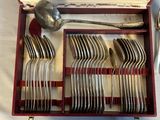 silverware in a wooden box with a spoon and spoon rest