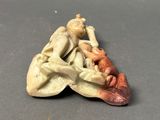 a small figurine of a man and a woman on a boat