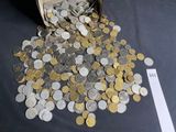 coins spilling out of a bucket on a table next to a piece of paper