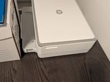 un ordinateur portable blanc posé sur une boîte, à côté d'une imprimante blanche
