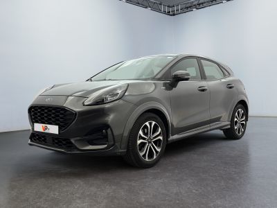 une voiture grise garée dans une grande pièce aux murs blancs