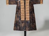 une sculpture en bois représentant la robe d'une femme, posée sur un socle