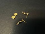 a pair of gold plated stud earrings on a black surface