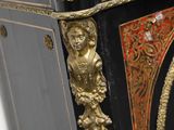 a black and gold cabinet with a clock on top of it