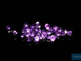 a close up of a bunch of purple crystals on a black surface