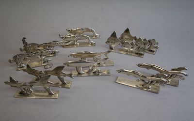 silver plated figurines of various types and sizes on a white surface