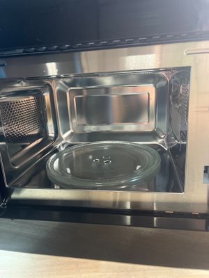 un micro-ondes argenté avec un plateau en verre à l'intérieur