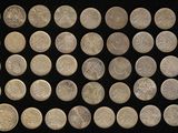 some silver coins are arranged in a row on a black surface