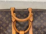 a brown and tan louis vuitton bag sitting on the ground