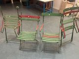 three green and red folding chairs sitting in a room next to a table