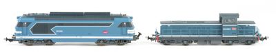 two toy trains sitting side by side on a white surface