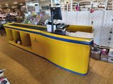 un comptoir jaune et bleu dans un magasin proposant de nombreux articles