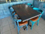 tables and chairs in a restaurant with blue walls and tile flooring
