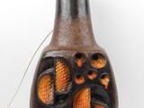 a brown and black vase with orange designs on it