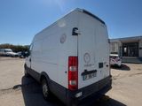 the back end of a white van parked in a parking lot