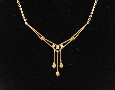 a gold plated necklace with a long chain and dangling drops