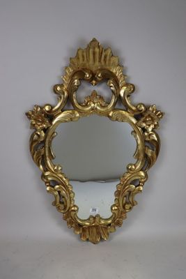un miroir au cadre doré ouvragé, orné d'un motif décoratif sur le pourtour