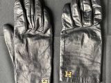 pair of black leather gloves sitting on top of a black table